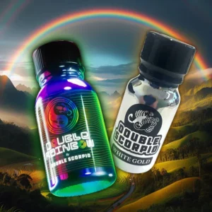 Two small bottles labeled "double rainbow" and "double scorpio white gold" are set against a vibrant backdrop of a double rainbow over a valley with terraced fields. The "double rainbow" bottle has a colorful, holographic design, while the "the golden fist pack" bottle is white and black, part of the exclusive golden fist pack.